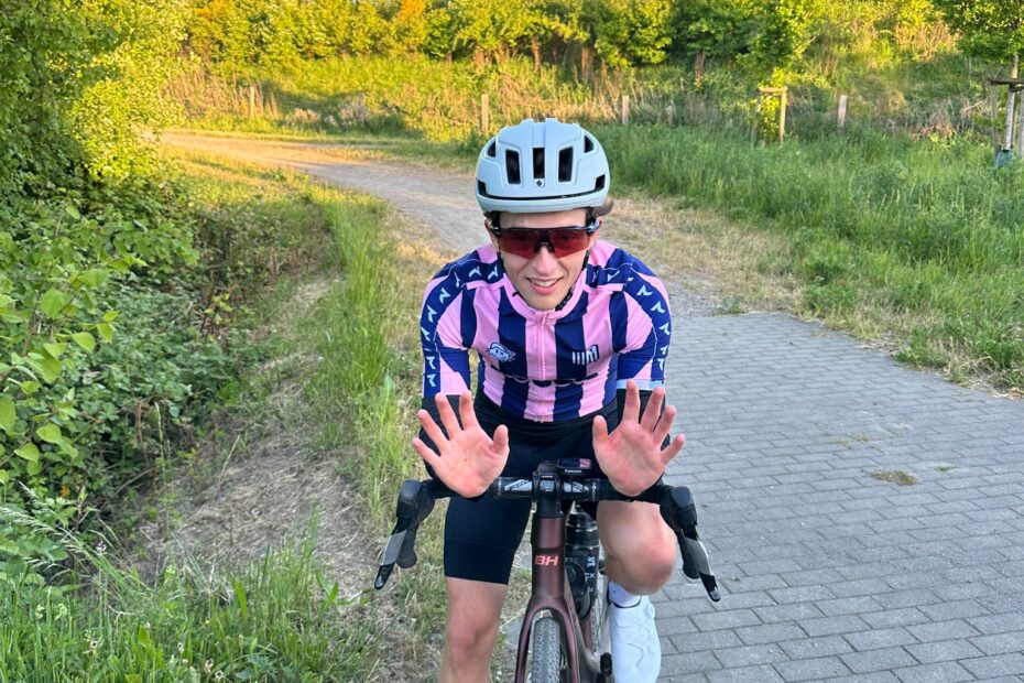 Junger Mann auf Gravelbike in der Natur um Hamburg hebt die Hände zur Begrüßung